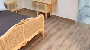 A bedroom with a bed, bedside tables, a dresser, and a framed picture on the wall.