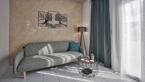 A modern living room with a grey sofa, a round coffee table, and a floor lamp.