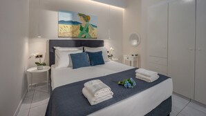 A modern bedroom with a large bed, a painting above the bed, a round mirror, and a wardrobe.