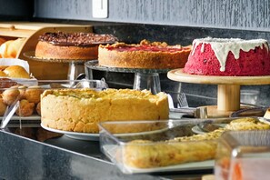 A variety of cakes and pastries displayed on a counter.