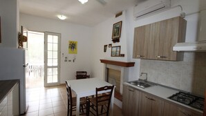 A kitchen with a dining table, chairs, a sink, and a stove. - Pugliacasealmare Rif. 1317 (Torre Pali)