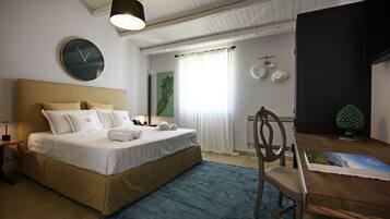 A bedroom with a bed, a desk, a chair, a clock, and a window with curtains.