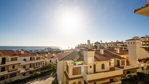 Ein Küstenwohngebiet mit terrakottafarbenen Dächern und weißen Gebäuden mit Blick aufs Meer.