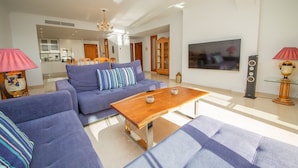 Ein modernes Wohnzimmer mit Sofa, Couchtisch und Fernseher.