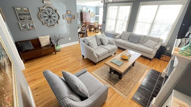 A living room with a sofa set, a coffee table, and a dining area with a table and chairs. - 2025 Masters Golf Tournament Rental (Evans)