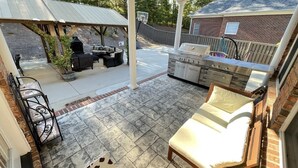 An outdoor patio with a grill, seating area, and a basketball hoop. - 2025 Masters Golf Tournament Rental (Evans)