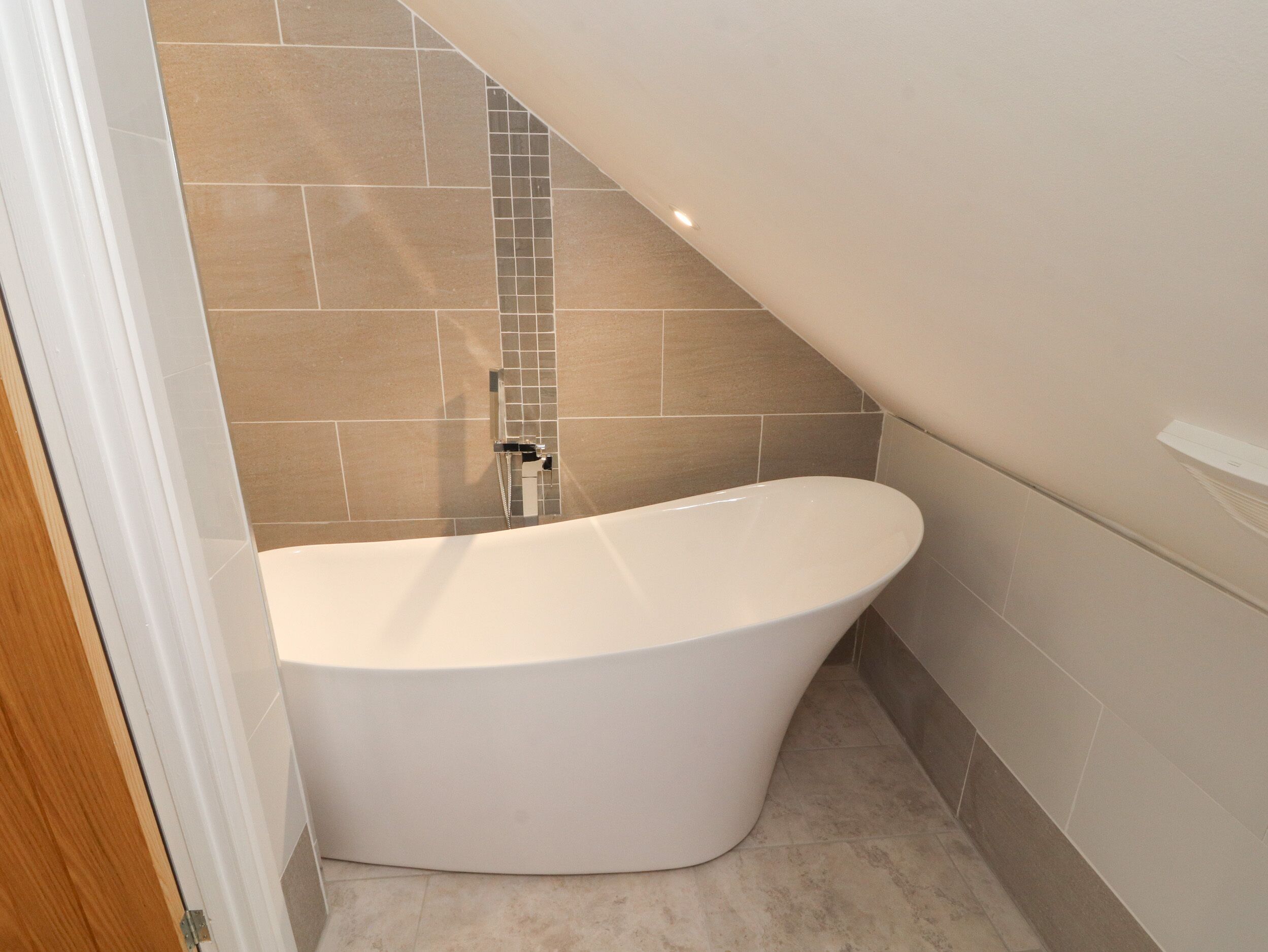 Une salle de bain moderne avec une baignoire sur pieds, des murs carrelés et un espace douche.