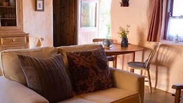 A cozy living room with a sofa, a small table, and a window.