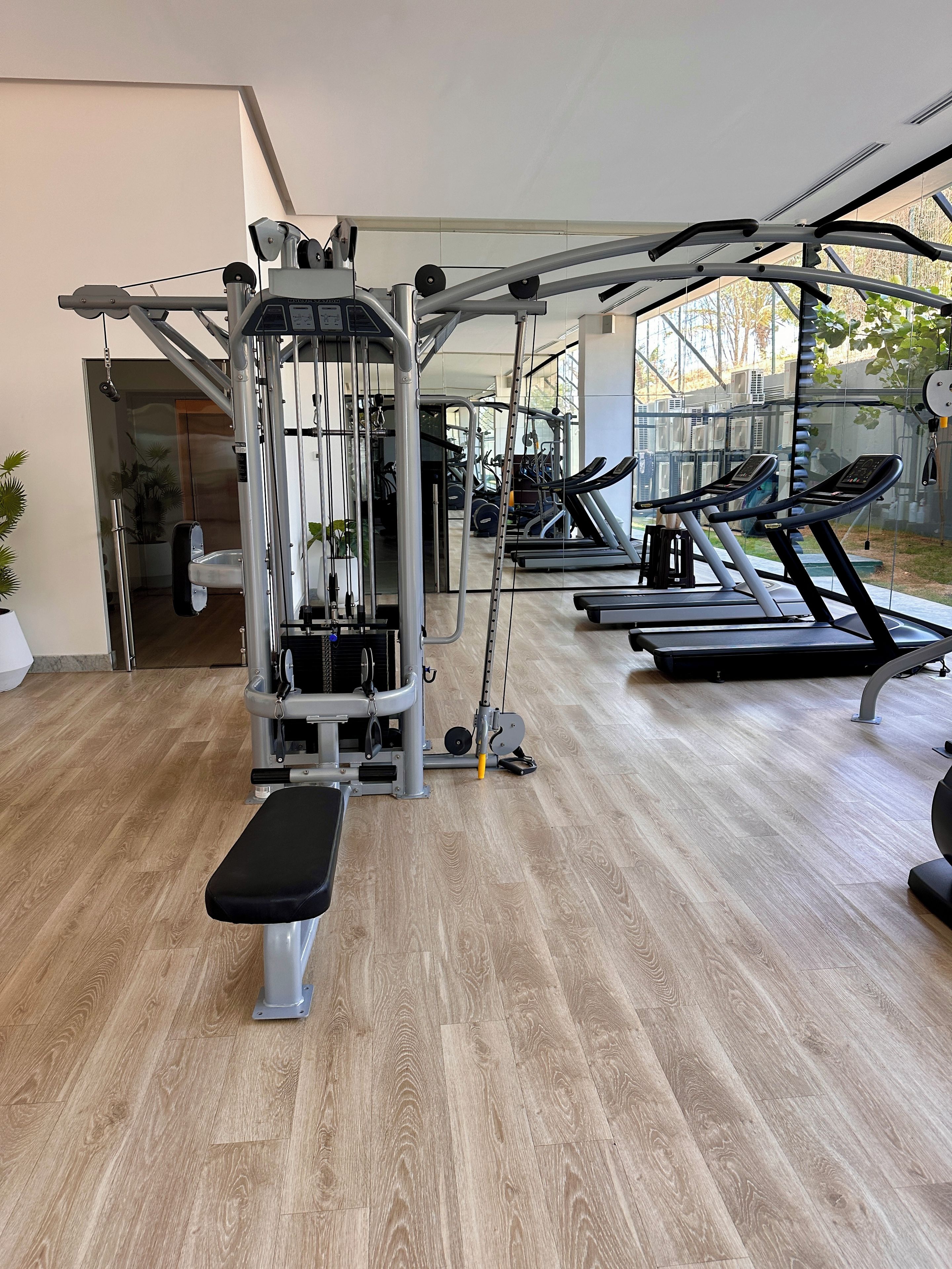 A gym with various exercise equipment, including a bench, treadmills, and weight machines.
