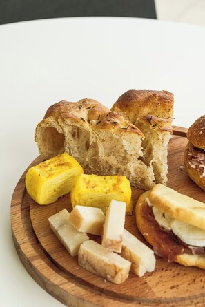 A wooden board with various food items including bread and cheese. - el Zhìgol (Farra di Soligo)