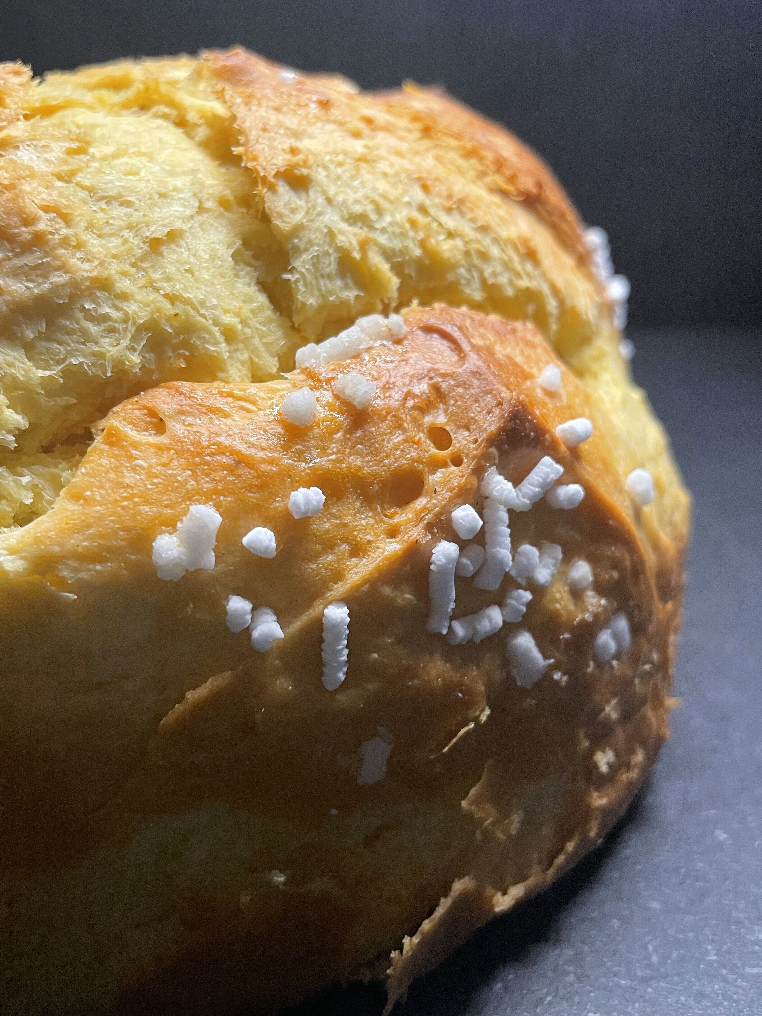 Une miche de pain à la croûte dorée, recouverte de cristaux de sucre blanc.