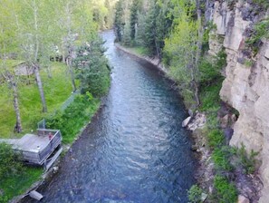 River views from a wooden viewing platform amidst lush greenery and rugged cliffs.