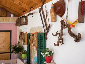 Cozy living area with a wooden ceiling, green-framed door, and potted plants.