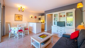 Un espace de vie compact comprenant un coin repas, une kitchenette et un coin salon.