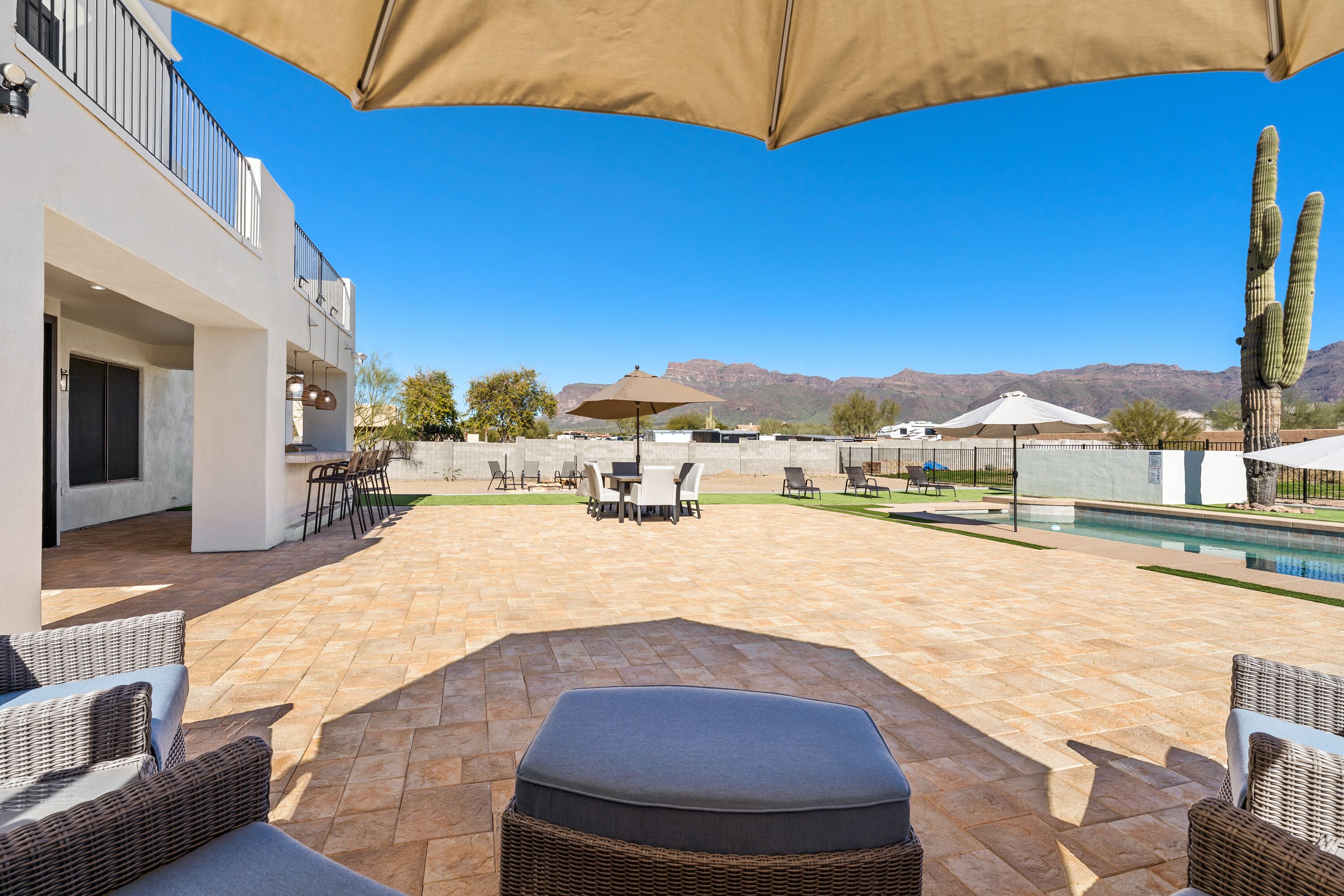 Un espace patio aménagé avec du mobilier d’extérieur, une piscine et une vue sur les montagnes.
