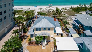 Una proprietà fronte spiaggia con un edificio grande, una piscina e vista sull'oceano.