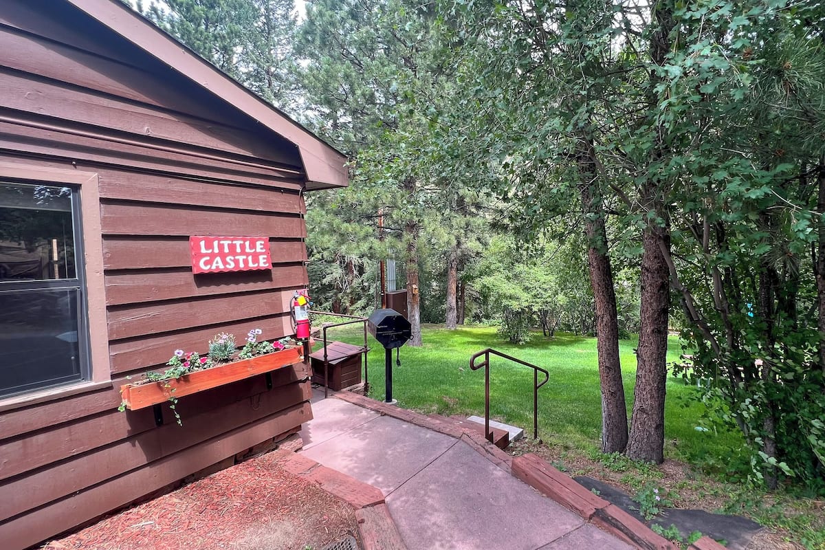 A wooden building labeled "Little Castle" with a mailbox and planter box.