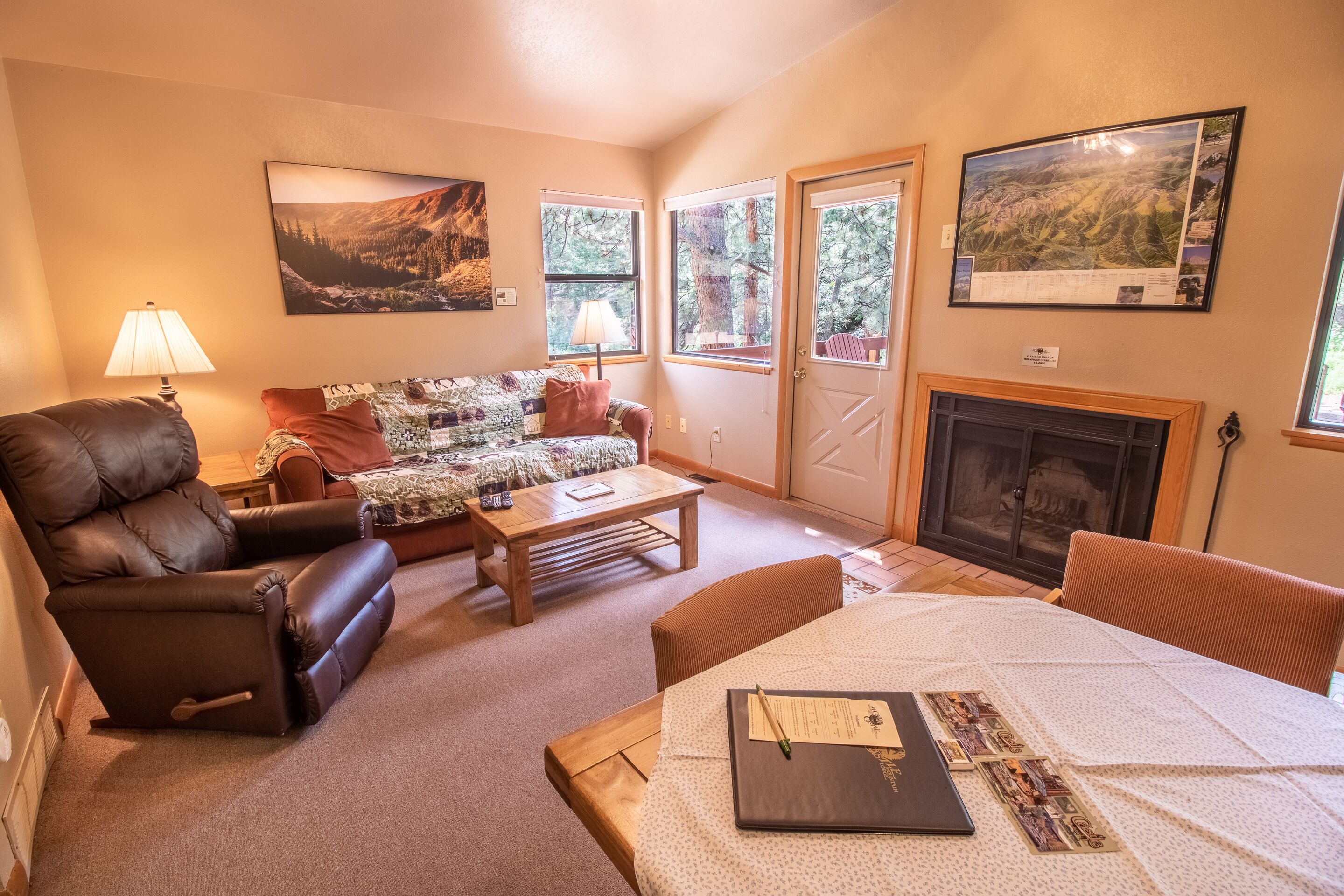 A cozy living room with a leather sofa, a wooden coffee table, and a fireplace.