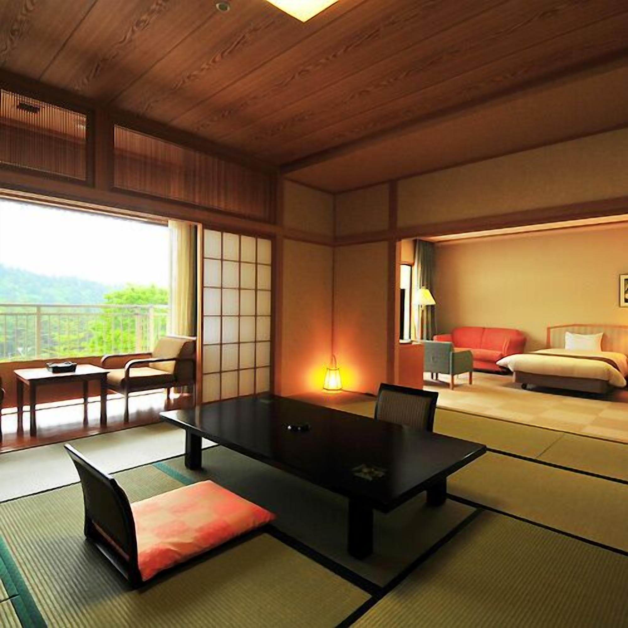 A traditional Japanese-style room with tatami flooring, a low table, and a sofa.