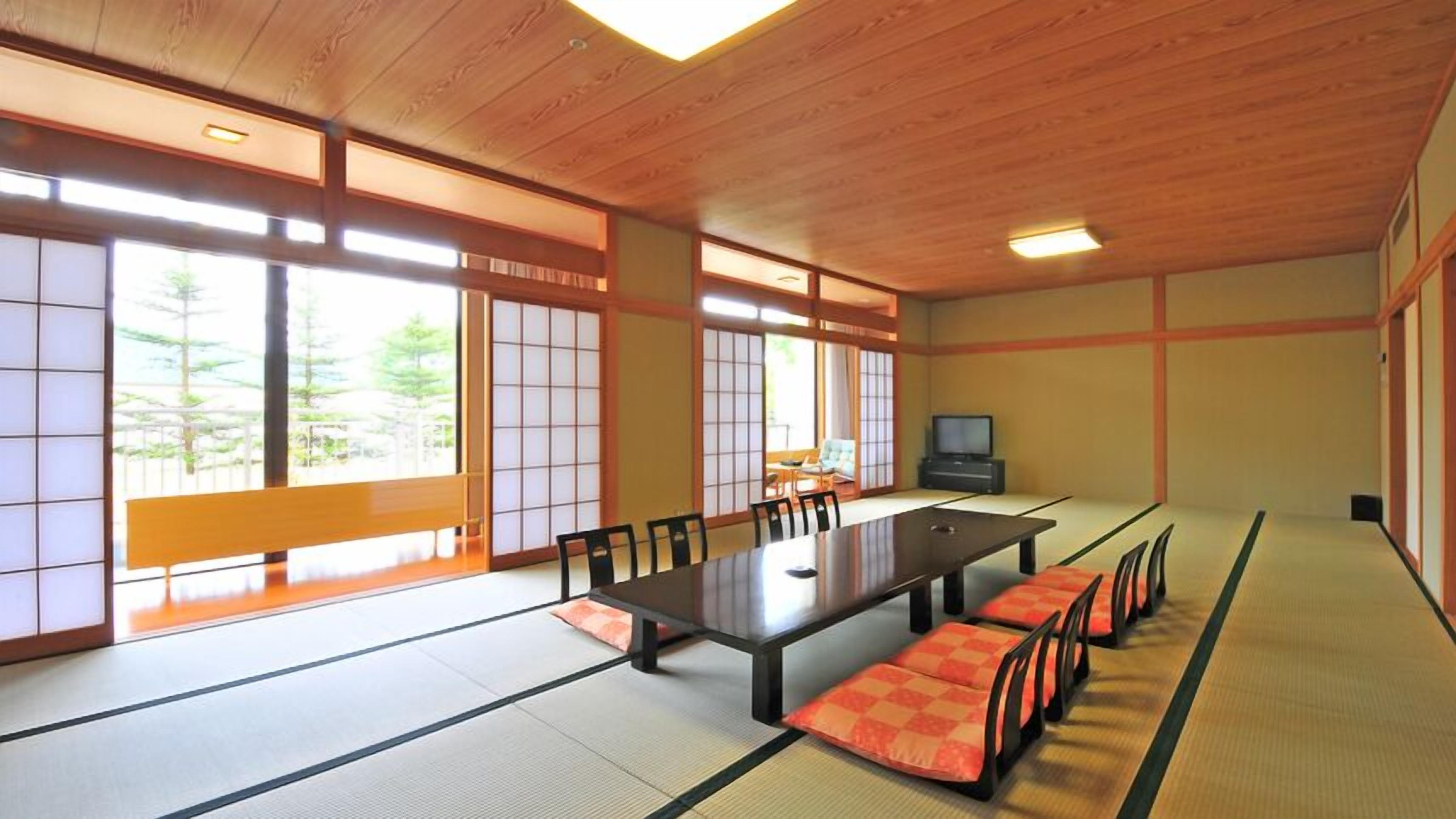 A traditional Japanese room with tatami flooring, a low table, and a television.