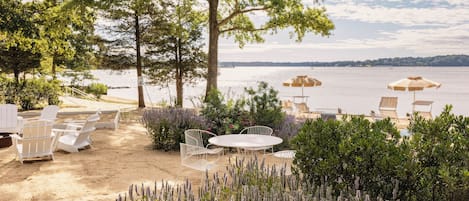 A lakeside patio with outdoor seating and a view of the water.