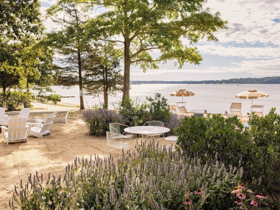 Un patio frente al lago con asientos al aire libre y vista al agua.