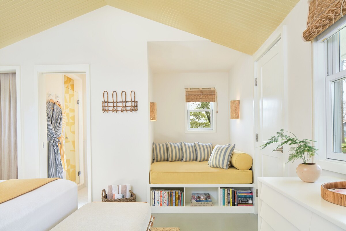 A cozy room with a built-in sofa, a bookshelf, and a window with a view.