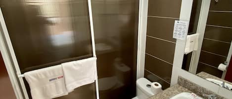 A bathroom with a shower, toilet, and sink.