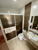 Un baño con ducha, inodoro y lavamanos.