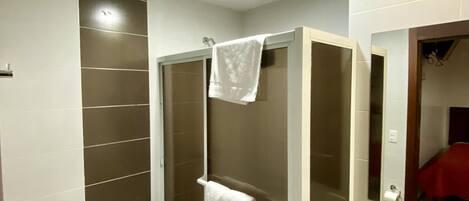 Un baño moderno con inodoro, ducha y lavamanos.