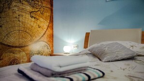 Un letto rifatto con una mappa e un comodino con una lampada.