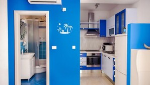 Una cucina moderna con mobili azzurri e bianchi, un forno a microonde, un forno e un frigorifero.