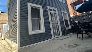 Una casa de dos pisos con garaje, un porche pequeño y una puerta principal visible.