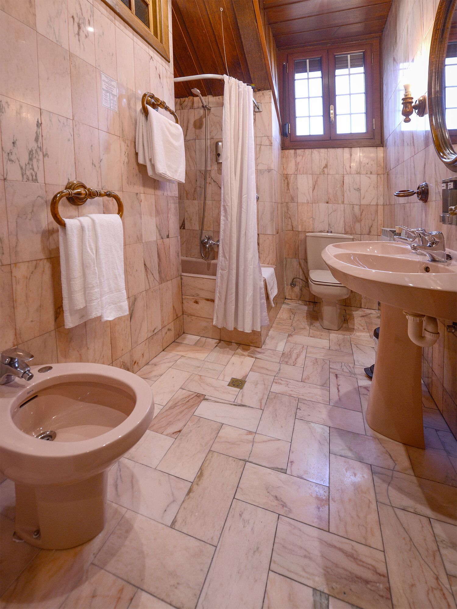 Un baño con bidé, inodoro, ducha y lavamanos.