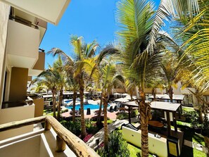 A pool area with palm trees and outdoor seating. - Ambar Apartments (Mazatlán)