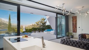 Una cocina moderna con un amplio ventanal, encimera blanca y pileta integrada.