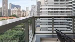 A modern building with a balcony and a view of a cityscape. - Setin Downtown República (São Paulo)