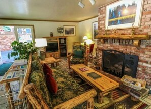 Cozy living room with a fireplace, comfortable seating area, and a television.