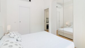 A modern bedroom with a large bed, a wardrobe, and a mirror. - Bright terrace in Milan (Milano)