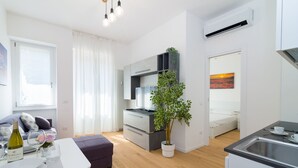 A modern, compact living space with a kitchenette, a dining area, and a bedroom. - Bright terrace in Milan (Milano)