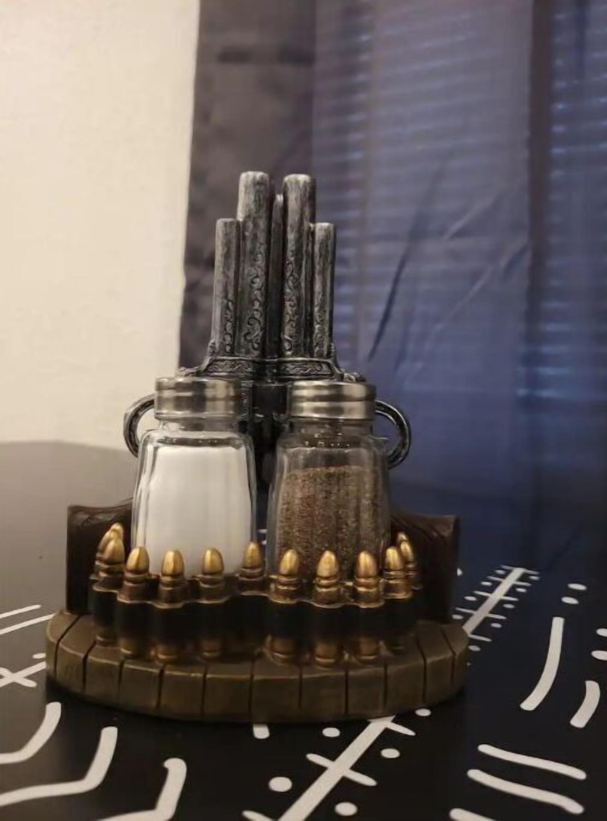 A decorative salt and pepper shaker set on a wooden tray with bullet-shaped accents.