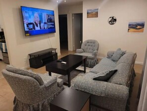 Relax in this stylish living room with a sofa set, armchair, and flat-screen TV.