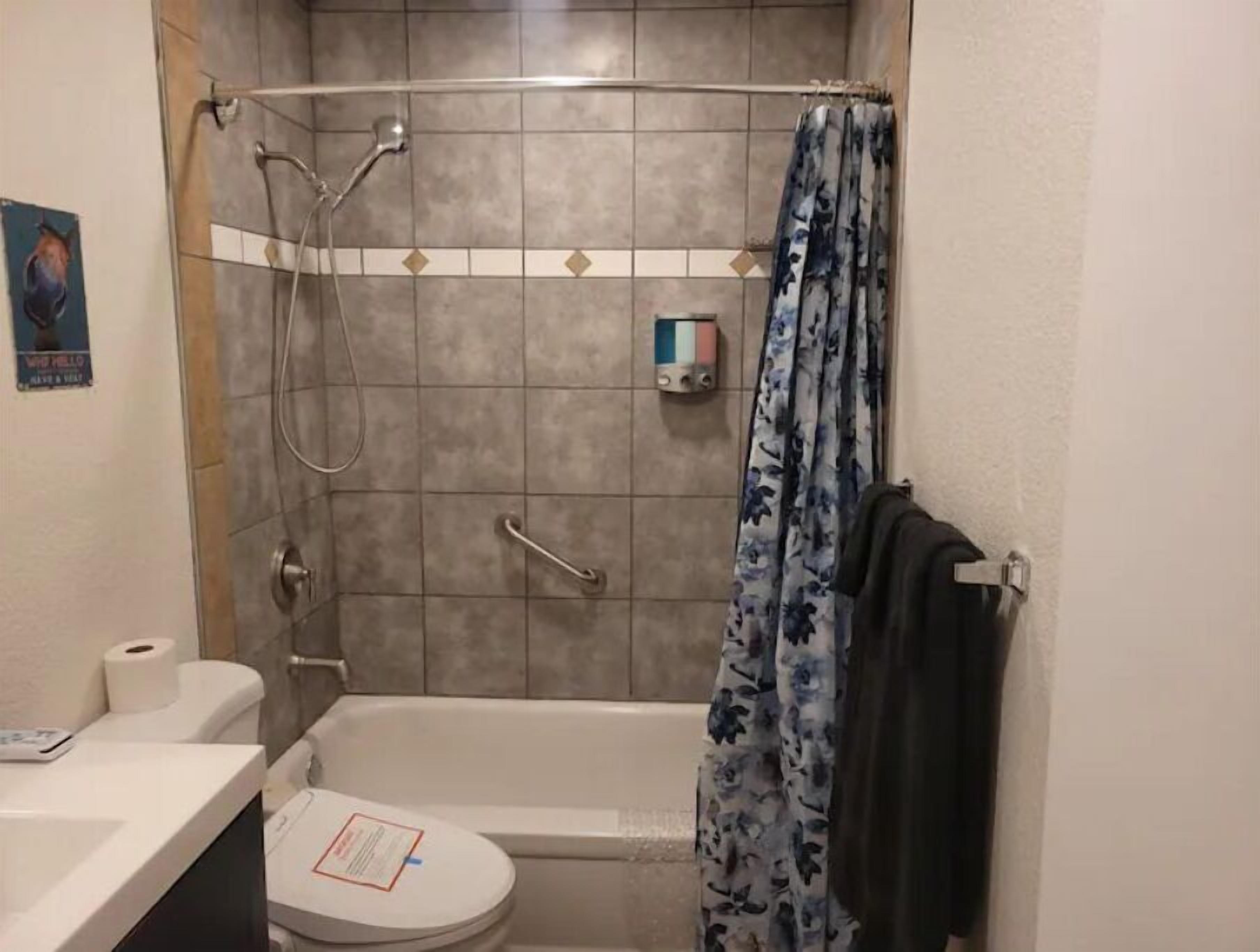 A bathroom with a shower, toilet, and sink.