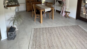 Ein geräumiger Wohnbereich mit einem Holzesstisch, Stühlen und einem großen Schrank.