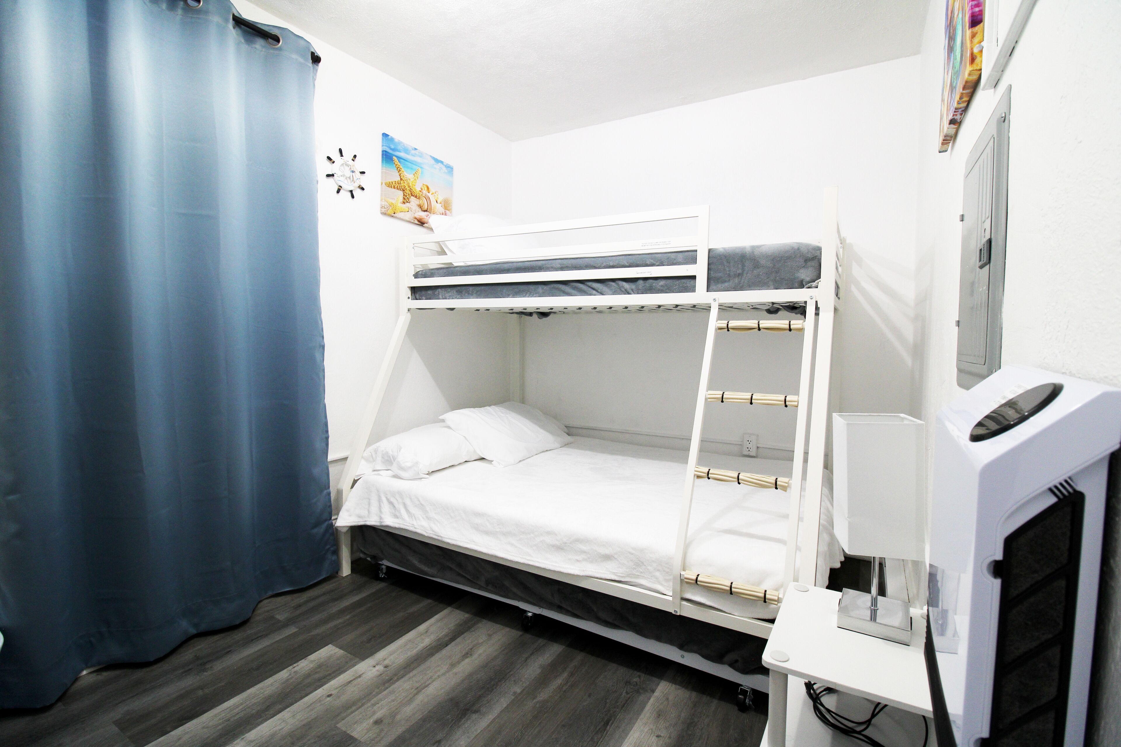 Une chambre avec un lit superposé, un bureau et un ordinateur.