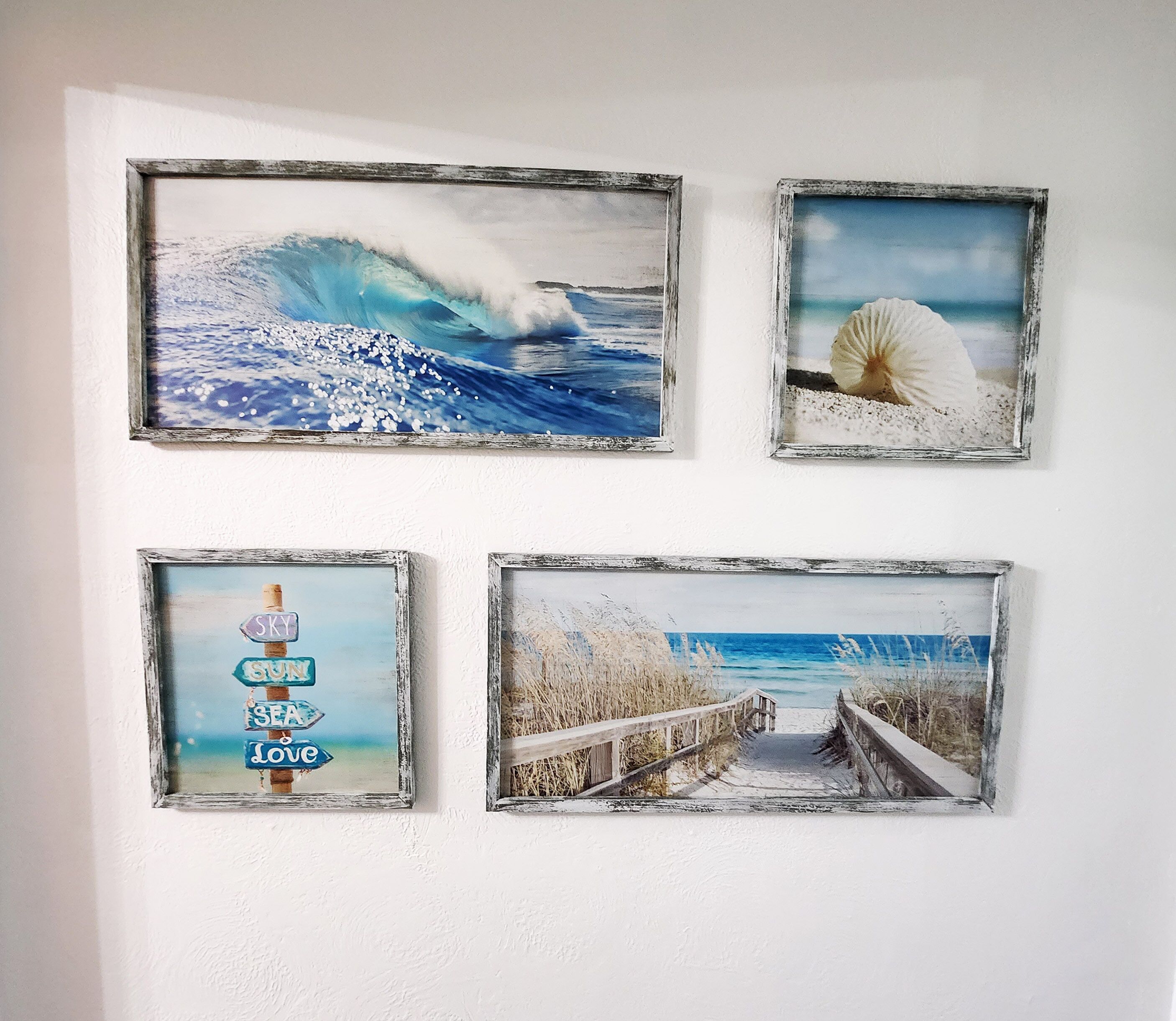 Four framed artworks on a wall.