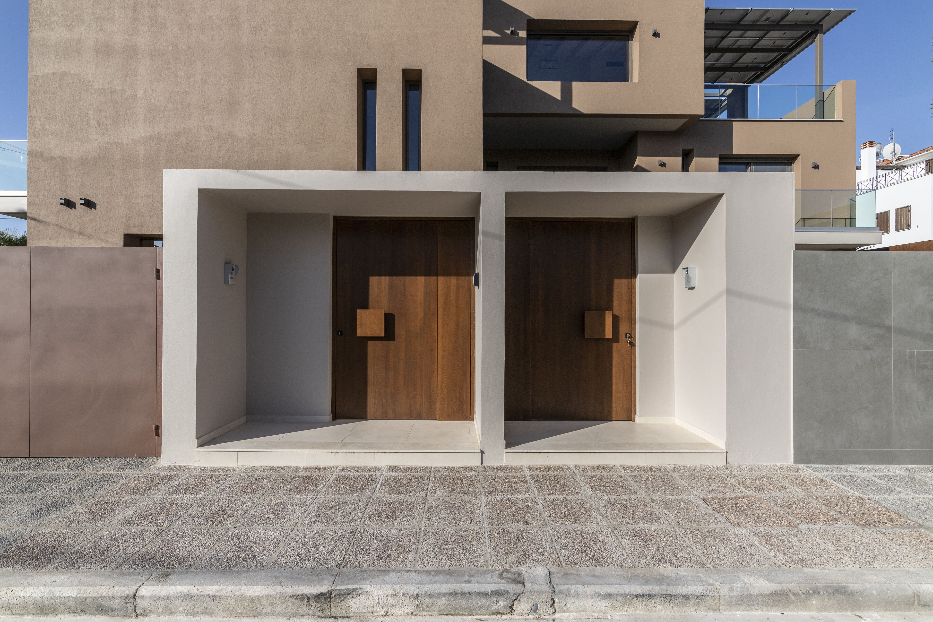 A modern building with two large wooden doors and a concrete facade.