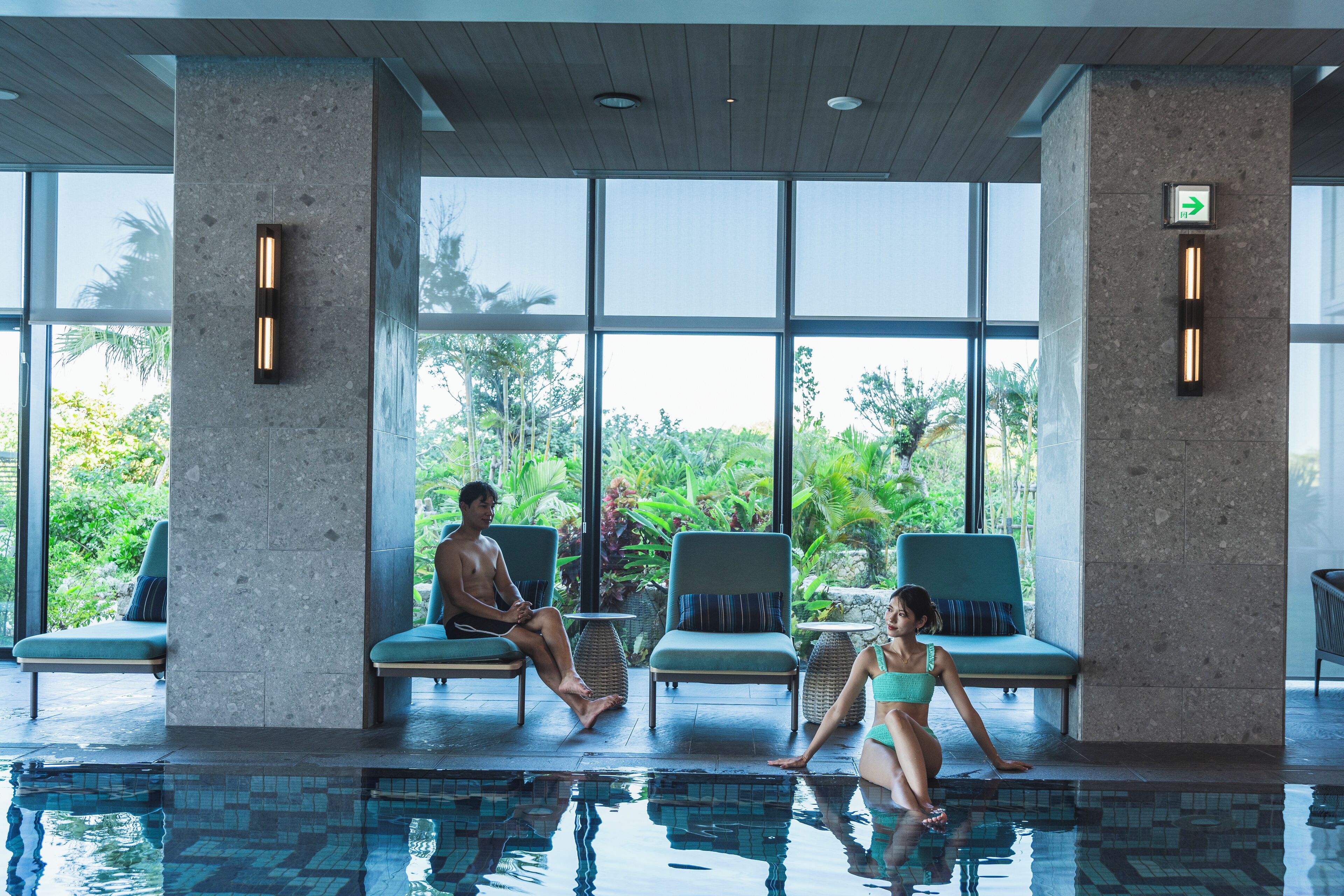 Un espace piscine avec des chaises longues et une vue sur la verdure environnante.