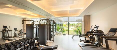 A modern gym with treadmills, dumbbells, and weight machines.