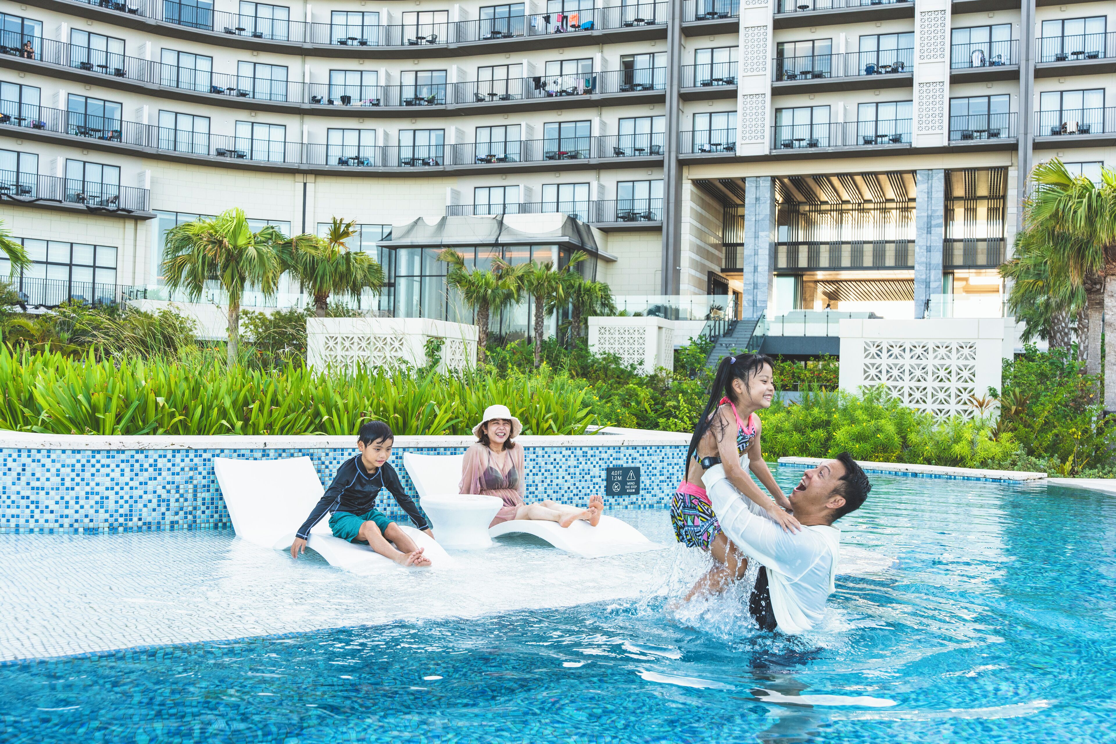 A swimming pool area with a modern building in the background.